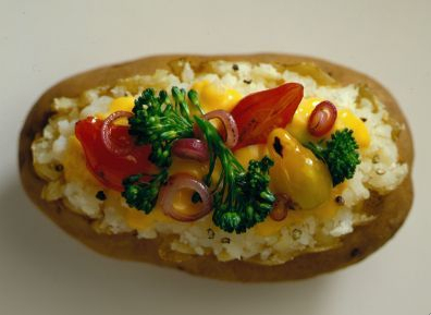 A baked potato topped with fresh vegetables and low-fat cheese is one healthy way to enjoy America's favorite vegetable.