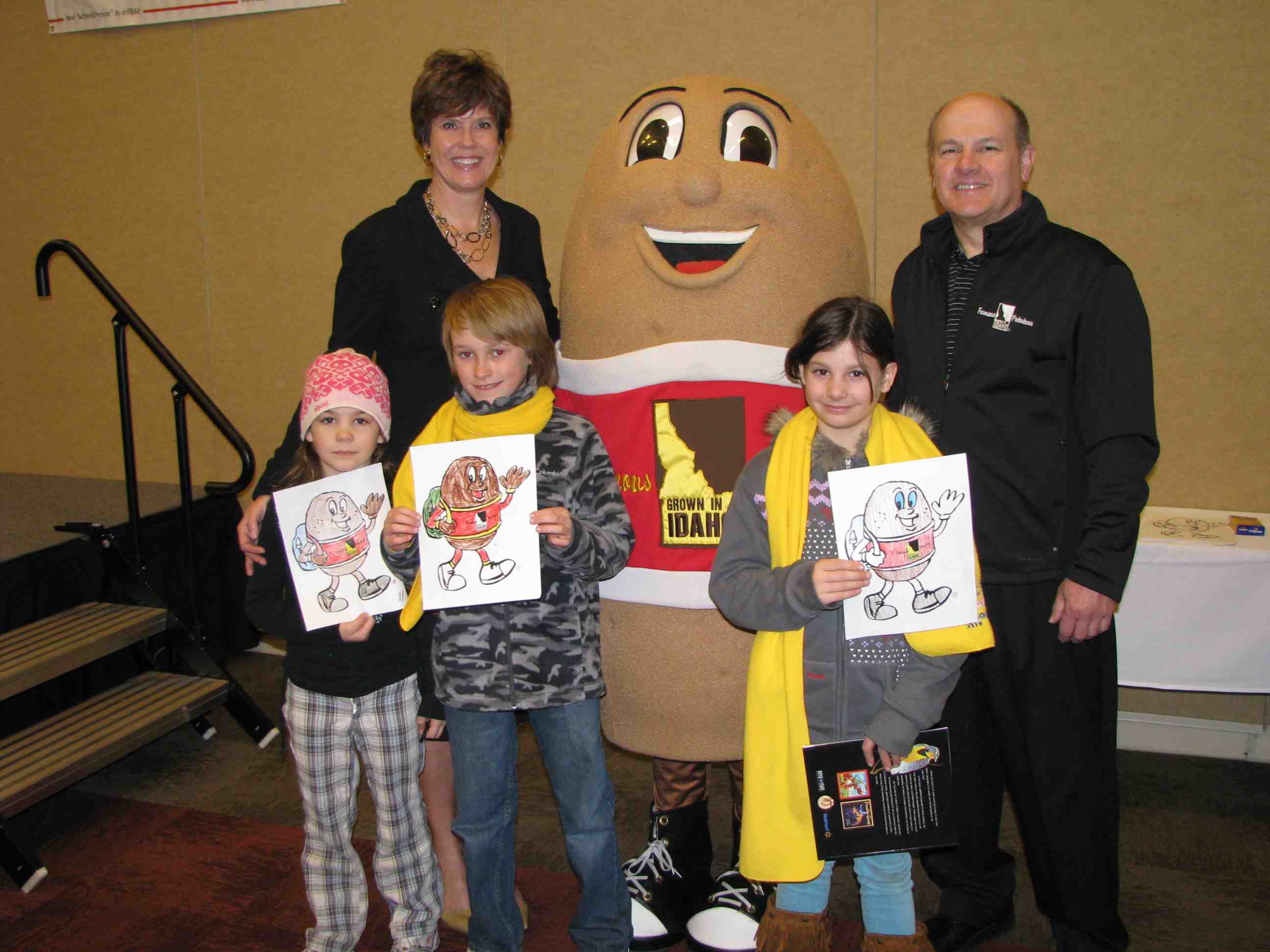 Lori Otter, Spuddy Buddy, and Frank Muir, President & CEO of the IPC help school children take a photo with their 